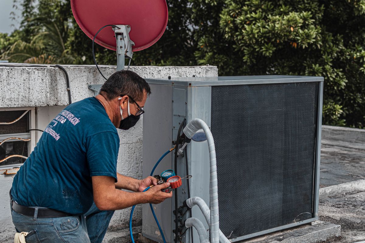 Technician checking an outdoor cooling system